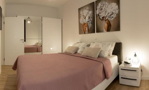 a bedroom with a large bed with a pink blanket at Apartment Palazzo, Zagreb town centre in Zagreb