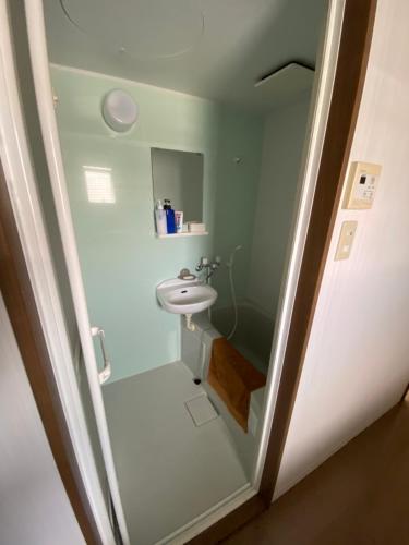 a small bathroom with a sink and a toilet at A&B Omoromachi Station in Naha
