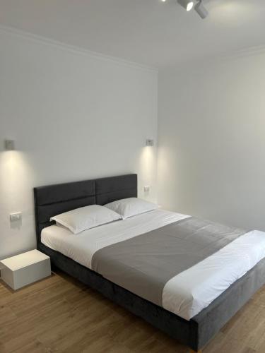 1 dormitorio con 1 cama grande y pared blanca en Nord 22 en Constanza