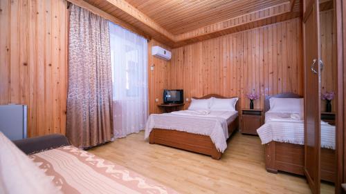 a room with two beds and a tv in it at Дом отдыха ира in Ureki