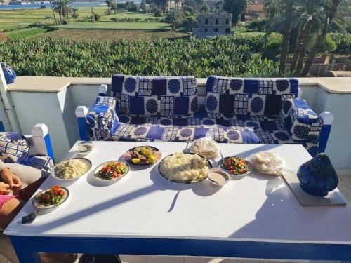 a white table with bowls of food on it at Villa Rebecca in Luxor