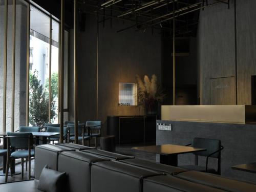 a dining room with tables and chairs and windows at NOA Hotel SHENZHEN LUOHU in Shenzhen