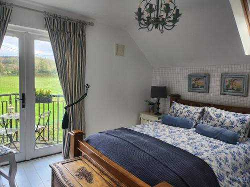 a bedroom with a bed and a balcony at Faithlegg Hotel Lodge in Waterford