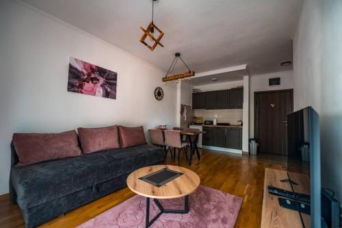 a living room with a couch and a table at Helena apartman in Ocka Gora