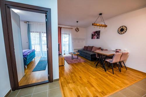 a living room with a table and a dining room at Helena apartman in Ocka Gora