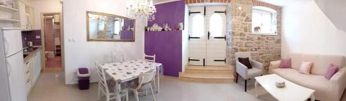 a living room with purple walls and a table and a couch at Two rustikal apartments in Vila ''U Kali'' close to the beach, reserved parking place in Sveti Filip i Jakov