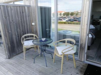 a patio with two chairs and a table and a table and chairs at Lägenhetshotell Varvet in Ellös