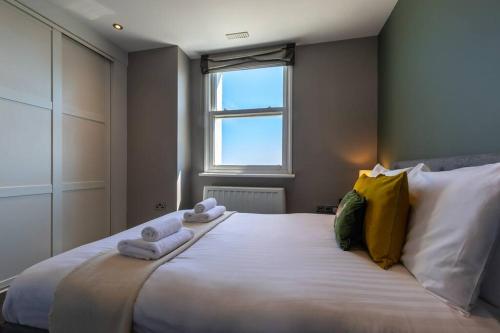 1 dormitorio con 1 cama blanca grande y toallas. en Sea Shell - 1 Bedroom Flat en Brighton & Hove
