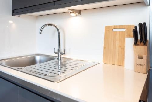 a kitchen counter with a sink and a knife block at Sea Shell - 1 Bedroom Flat in Brighton & Hove