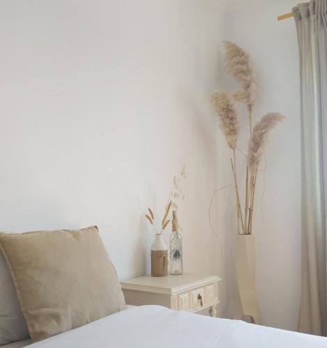 a bedroom with a bed and a table with plants at Villa Intuitiva - Relaxation and Mindful Stay in Lourinhã