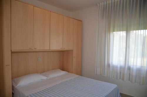 una camera con letto, armadio e finestra di Ville Maitè a Bibione