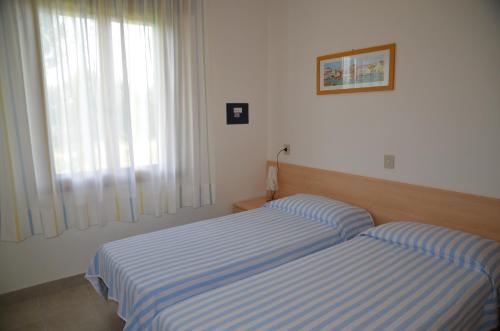 una camera con due letti e una finestra di Ville Maitè a Bibione