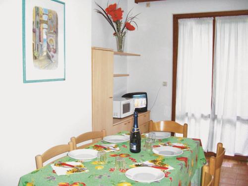 un tavolo con una tovaglia verde e una bottiglia di vino di Ville Maitè a Bibione