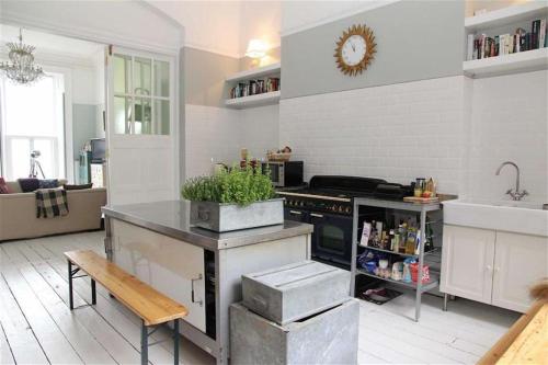 a kitchen with a sink and a stove top oven at Stunning Period & Family Apartment by the Sea in St. Leonards