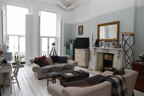 a living room with two couches and a fireplace at Stunning Period & Family Apartment by the Sea in St. Leonards