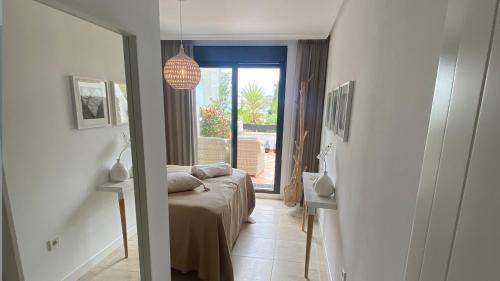 - une chambre avec un lit et une porte donnant sur une terrasse dans l'établissement Sunset Golf Urbanisation - La Rasina Golf and Country Club, à Estepona
