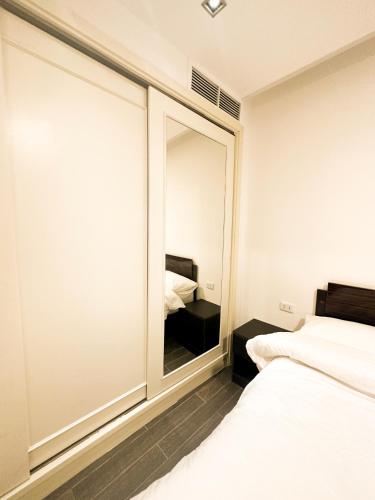 a bedroom with a large mirror and two beds at central apartment for rent 27 in Umm Uthainah