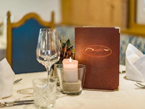 a table with a candle and a wine glass at Hotel Der Wastlhof - Pools, Spa & eigene Reitschule in Niederau