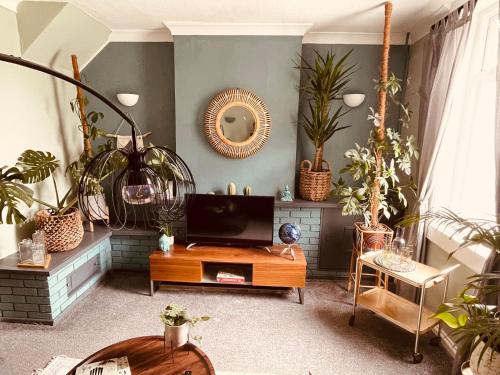 a living room filled with plants and a tv at Newmarket Cosy Stay in Newmarket