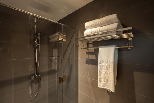 a bathroom with a shower and some towels at AD Hotel Pont D'Hydra in Hydra