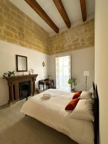 um quarto com uma cama grande e uma lareira em L'Artist Casa Micallef em Valletta