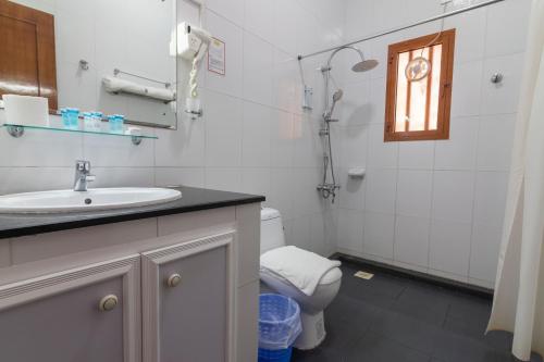 a bathroom with a sink and a toilet and a window at Al Ayjah Plaza Hotel in Sur