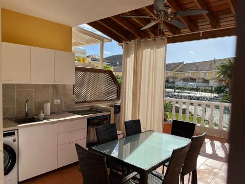 cocina con mesa y sillas y balcón en El Camison Apartment, en Playa de las Américas