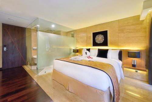 a large bedroom with a large bed and a shower at de Vins Sky Hotel Seminyak in Seminyak