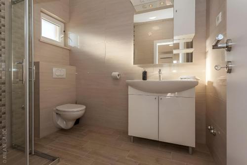 a bathroom with a toilet and a sink and a shower at Amazing Villa Grande with swimming pool in Sveti Petar