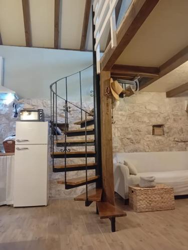 a spiral staircase in a room with a stone wall at Holiday home Mimara in KoruÅ¡ce