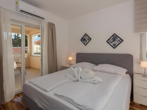 a white bed with a towel on it in a bedroom at Amazing Villa Grande with swimming pool in Sveti Petar