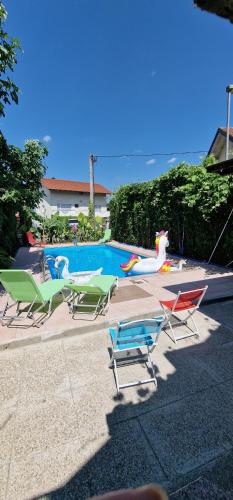 a group of lawn chairs next to a swimming pool at APARTMAN MURKO P-4 in Ljubljana