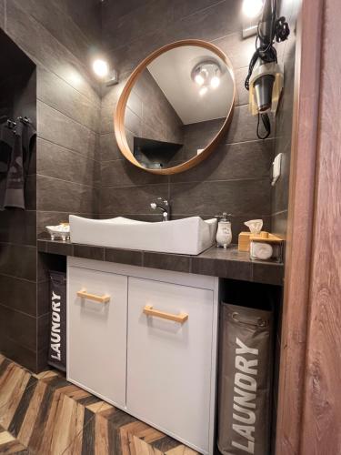 a bathroom with a sink and a mirror at Apartament Harmony in Dębogórze