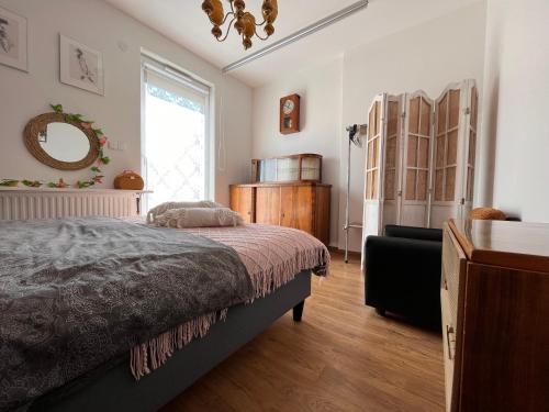 a bedroom with a bed and a dresser and a window at Apartament Harmony in Dębogórze