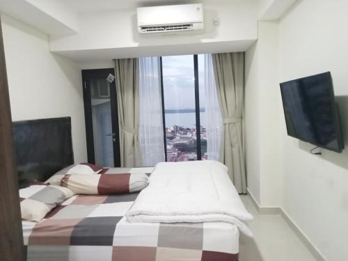 una camera d'albergo con due letti e una finestra di Apartement Studio Pollux Habibi Batam A13712 a Batam Center