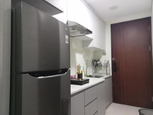 a kitchen with a black refrigerator and a sink at Apartement Studio Pollux Habibi Batam A13715 HOT PROMOTION WITHOUT WIFI in Batam Center