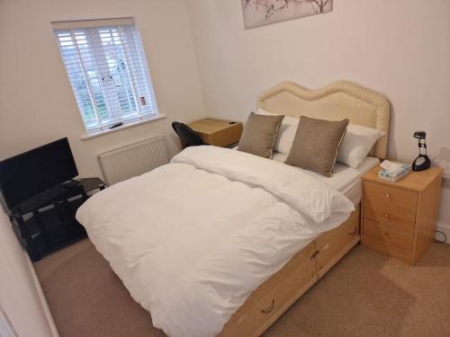 a bedroom with a bed and a television in it at NightRest Homes 6 Bedroom House- Smart TV In each Room - Parking - Wifi -Milton Keynes in Milton Keynes