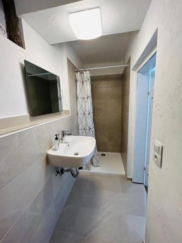 a white bathroom with a sink and a shower at EZ im Herzen von Gladenbach in Gladenbach