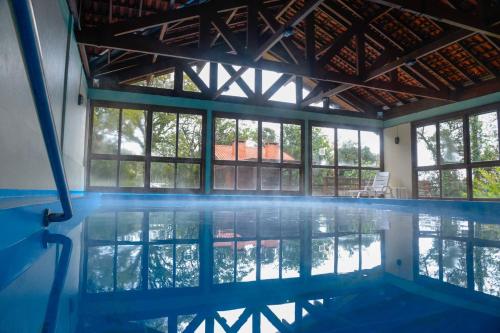 an empty swimming pool with windows in a building at Pousada do Serrano in Gramado