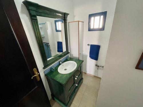 baño con lavabo verde y espejo en El descanso de Bielo Lanzarote, en Caleta de Caballo