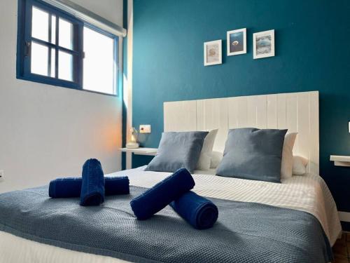 1 dormitorio con 1 cama grande y paredes azules en El descanso de Bielo Lanzarote, en Caleta de Caballo