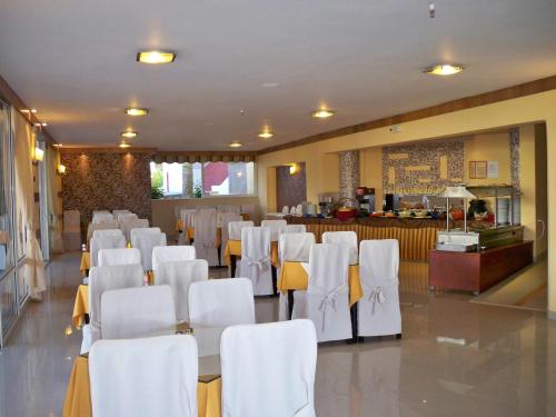a room with white chairs and a table and a bar at Palladion in Adelianos Kampos