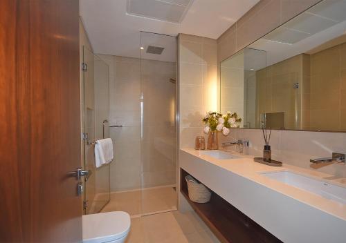 a bathroom with a shower and a sink and a toilet at Marina Gate Modern & Unique 1 Bed by AirDHP in Dubai