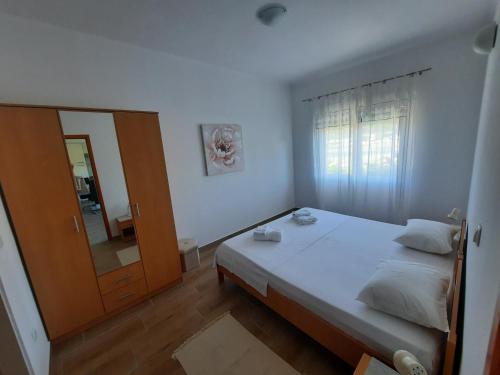 a small bedroom with a bed and a mirror at MaroVito in Supetarska Draga