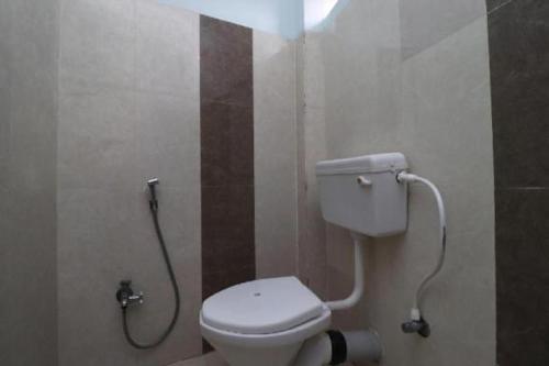 a bathroom with a white toilet in a stall at HOTEL J B PALACE in Rāmgarh