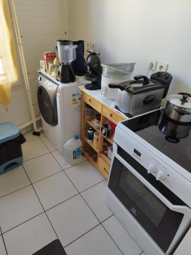 een keuken met een fornuis en een koelkast bij 2 pièces à St Germain en Laye in Saint-Germain-en-Laye