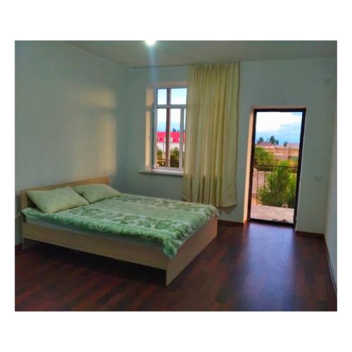 1 dormitorio con cama y ventana con vistas en СафияGold, en Cholpon-Ata