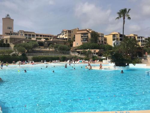 un groupe de personnes dans une grande piscine dans l'établissement P2 VILLAGE CLUB CAP ESTEREL Vue Golf et Mer, Piscine Chauffée, à Saint-Raphaël