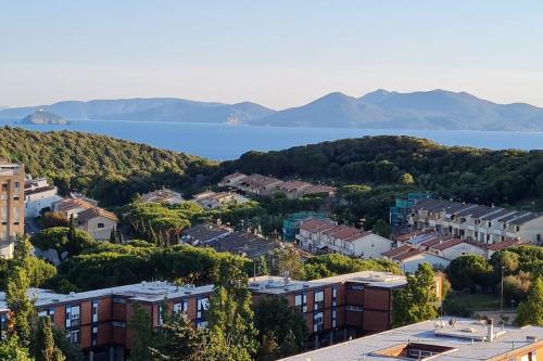 a city with houses and a lake in the background at Prospettiva Mare Apartament in Piombino