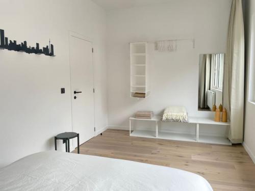 um quarto branco com uma cama branca e piso em madeira em #2800ourhome 201 em Mechelen